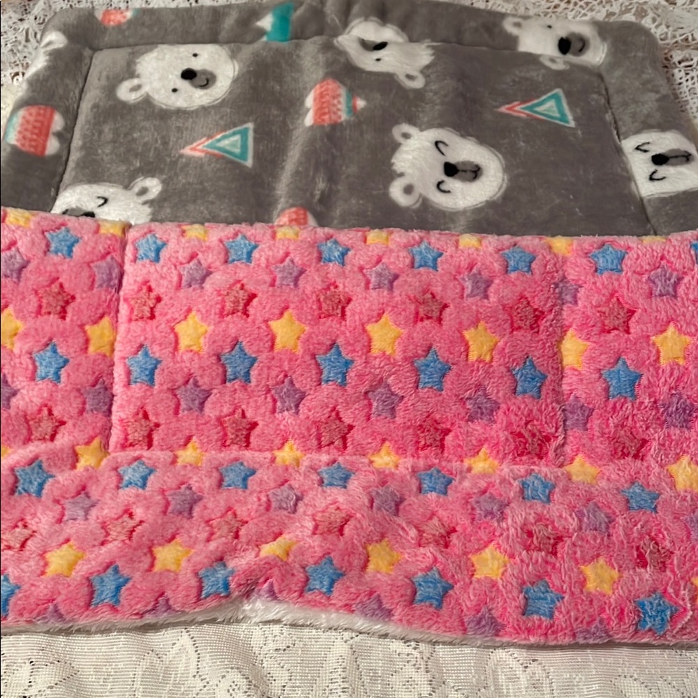 Two small puppy pads. One pink with stars and the other is gray with bears.